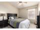 Cozy bedroom with ceiling fan, window and a bed with decorative pillows and a green patterned comforter at 7930 W Wescott Dr, Glendale, AZ 85308