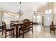 Dining room featuring travertine floors, a modern light fixture, and a large dining table with chairs at 7930 W Wescott Dr, Glendale, AZ 85308