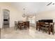 Dining room featuring travertine floors, a modern light fixture, and a large dining table with chairs at 7930 W Wescott Dr, Glendale, AZ 85308
