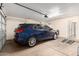 A well lit, two car garage features a blue SUV and room for storage at 7930 W Wescott Dr, Glendale, AZ 85308