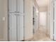 Bright hallway with storage cabinets, tile flooring, and doorways leading to other rooms at 7930 W Wescott Dr, Glendale, AZ 85308