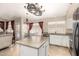 Open kitchen layout with island, stainless steel appliances, and dining area with a small, round table at 7930 W Wescott Dr, Glendale, AZ 85308