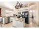 Bright kitchen featuring white cabinets, stainless steel appliances, and center island with lovely chandelier at 7930 W Wescott Dr, Glendale, AZ 85308