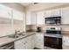 Close up of kitchen with stainless steel appliances, double sink, granite countertops and white cabinets at 7930 W Wescott Dr, Glendale, AZ 85308