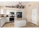 Kitchen with white cabinets, center island, stainless steel appliances, and tan-colored granite countertops at 7930 W Wescott Dr, Glendale, AZ 85308