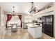 Open kitchen with center island, stainless steel appliances, white cabinets, and adjacent dining area at 7930 W Wescott Dr, Glendale, AZ 85308