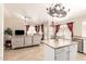A living room with dark red curtains, island and view to a kitchen with bright light at 7930 W Wescott Dr, Glendale, AZ 85308