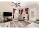Cozy living room with ceiling fan, plush seating, and a large television, perfect for relaxation at 7930 W Wescott Dr, Glendale, AZ 85308