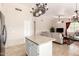 Open floor plan shows island, chandelier and an open living room with ceiling fan and window at 7930 W Wescott Dr, Glendale, AZ 85308
