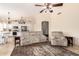 Spacious living room with plush seating, ceiling fan, and an open layout connecting to the kitchen and dining area at 7930 W Wescott Dr, Glendale, AZ 85308