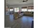 Spacious living room and dining area featuring wood-look tile floors and abundant natural light at 8678 S John Jacob Astor Ave, Casa Grande, AZ 85193