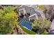 An aerial view displays the backyard with an infinity pool, tile roof and lush greenery at 9265 N 115Th St, Scottsdale, AZ 85259