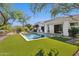 The backyard features an infinity pool, turf, mature trees, and a covered patio at 9265 N 115Th St, Scottsdale, AZ 85259
