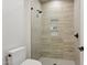 Bathroom includes a glass-enclosed shower with built in storage and fixtures with a matching toilet at 9265 N 115Th St, Scottsdale, AZ 85259