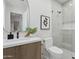 Bright bathroom featuring a modern sink vanity, decorative oval mirror, and a glass-enclosed walk-in shower at 9265 N 115Th St, Scottsdale, AZ 85259