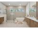 Luxurious bathroom with sleek vanity, soaking tub, glass enclosed shower, and views of the trees outside at 9265 N 115Th St, Scottsdale, AZ 85259