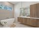 Gorgeous bathroom features soaking tub, modern vanity, sleek hardware, and bright natural light at 9265 N 115Th St, Scottsdale, AZ 85259