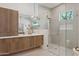 Stunning bathroom with dual sink vanity, sleek cabinetry, walk-in shower, and modern design elements at 9265 N 115Th St, Scottsdale, AZ 85259