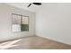 An empty bedroom is brightened by a window with trimmed hedges seen from within the space at 9265 N 115Th St, Scottsdale, AZ 85259