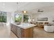 Modern kitchen with a center island seamlessly connects to a stylish living area and large windows at 9265 N 115Th St, Scottsdale, AZ 85259