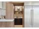 Kitchen detail showcasing wood cabinetry, built-in shelves, and stainless steel refrigerator at 9265 N 115Th St, Scottsdale, AZ 85259