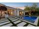 Stunning pool with modern paver design and lush landscaping off the back of this white home at 9265 N 115Th St, Scottsdale, AZ 85259
