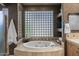 Elegant bathroom featuring a soaking tub and decorative glass block window at 9432 N Longfeather --, Fountain Hills, AZ 85268