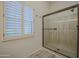Clean bathroom featuring walk-in shower with glass door and plantation shutters at 9813 W Mcrae Way, Peoria, AZ 85382
