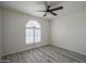 Inviting bedroom featuring tile floors, ceiling fan, and a unique arched window at 9813 W Mcrae Way, Peoria, AZ 85382
