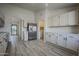 Bright kitchen with white cabinets, stainless steel appliances, and wood grain flooring at 9813 W Mcrae Way, Peoria, AZ 85382