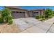 Large concrete driveway leading to the garage and accented by manicured landscaping at 9922 E Thunderbolt Ave, Mesa, AZ 85212