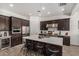 Bright kitchen featuring stainless steel appliances, a center island, and stylish dark wood cabinets at 9922 E Thunderbolt Ave, Mesa, AZ 85212