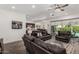Open concept living room with dark leather sofas, ceiling fan and access to the backyard at 9922 E Thunderbolt Ave, Mesa, AZ 85212
