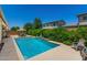 Backyard pool with lush greenery and a small waterfall feature, creating a private oasis at 9922 E Thunderbolt Ave, Mesa, AZ 85212