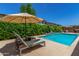 Outdoor patio area with lounge chairs next to the pool, perfect for relaxation and enjoying sunny days at 9922 E Thunderbolt Ave, Mesa, AZ 85212