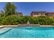 Close-up of a backyard pool with a serene waterfall feature and lush landscaping, offering tranquility at 9922 E Thunderbolt Ave, Mesa, AZ 85212