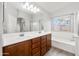 Bright bathroom featuring a double vanity, soaking tub, and large mirror at 1015 E Penny Ln, San Tan Valley, AZ 85140