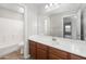 Bright bathroom featuring a vanity, white countertop, large mirror, and combined tub and shower at 1015 E Penny Ln, San Tan Valley, AZ 85140