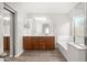 Bright bathroom with a double vanity, soaking tub, and wood-look flooring at 1015 E Penny Ln, San Tan Valley, AZ 85140