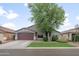 Charming single-story home with a well-maintained front yard and two-car garage under a partly cloudy sky at 1015 E Penny Ln, San Tan Valley, AZ 85140