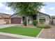 Single-story home featuring manicured landscaping, a two-car garage, and an inviting entrance at 1015 E Penny Ln, San Tan Valley, AZ 85140