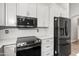 Close-up of modern kitchen appliances, featuring a black stainless-steel refrigerator and a sleek stovetop at 1015 E Penny Ln, San Tan Valley, AZ 85140