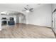 Spacious living room showcasing an open layout with a kitchen, gray wood floors, and lots of natural light at 1015 E Penny Ln, San Tan Valley, AZ 85140