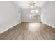 Bright living room with high ceilings, arched doorway, picture window, gray walls, and wood-look floors at 1015 E Penny Ln, San Tan Valley, AZ 85140
