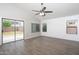 Bright living room with gray flooring, shiplap accent wall, and sliding door access to the backyard at 1015 E Penny Ln, San Tan Valley, AZ 85140