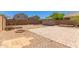 Expansive backyard with gravel landscaping, mature trees, a storage shed, and a tiled patio at 10745 W Taft St, Phoenix, AZ 85037