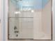 Bathroom with shower and glass door, white tiled walls, and neutral fixtures at 10745 W Taft St, Phoenix, AZ 85037