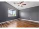 Bedroom with wood floors, window with a view, and ceiling fan offering both style and comfort at 10745 W Taft St, Phoenix, AZ 85037