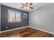 Bedroom boasts modern fan, window view, and dark accent wall, offering a stylish retreat at 10745 W Taft St, Phoenix, AZ 85037