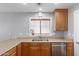 Kitchen featuring a stainless steel sink, modern appliances, and wooden cabinetry at 10745 W Taft St, Phoenix, AZ 85037